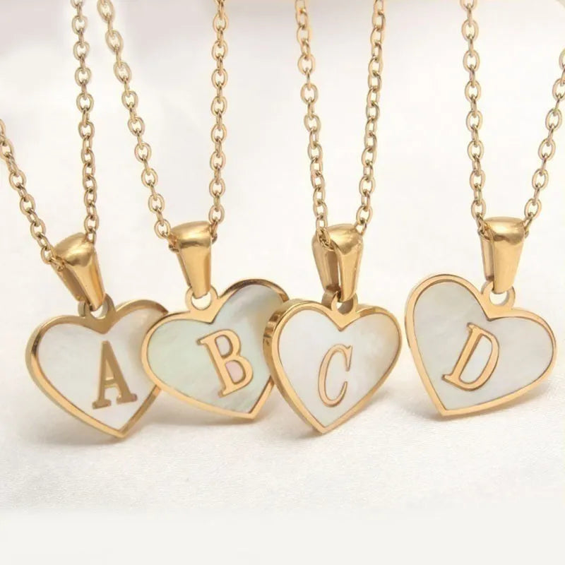 Gold chain necklace with white shell heart pendant featuring single letter customisation option