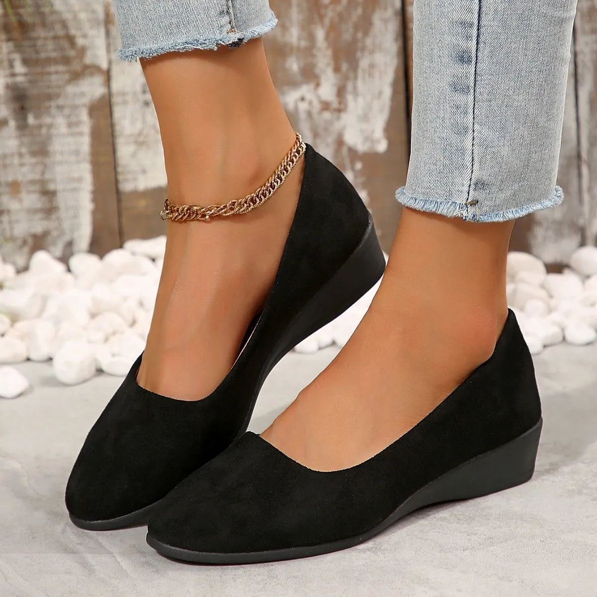 Women's black suede wedge pumps with a low block heel and pointed toe on a rubber sole.