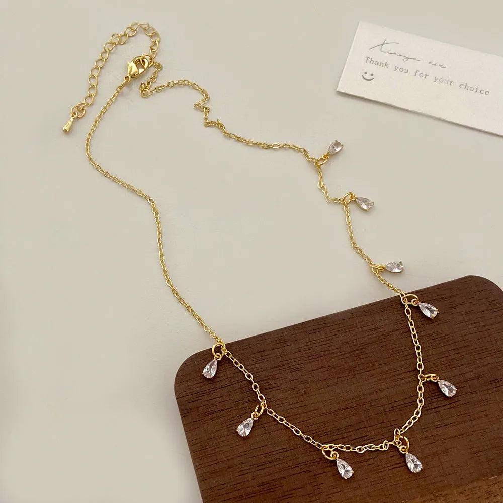 Women's zircon jewellery set showing necklace, earrings and anklet with geometric meteor shower design