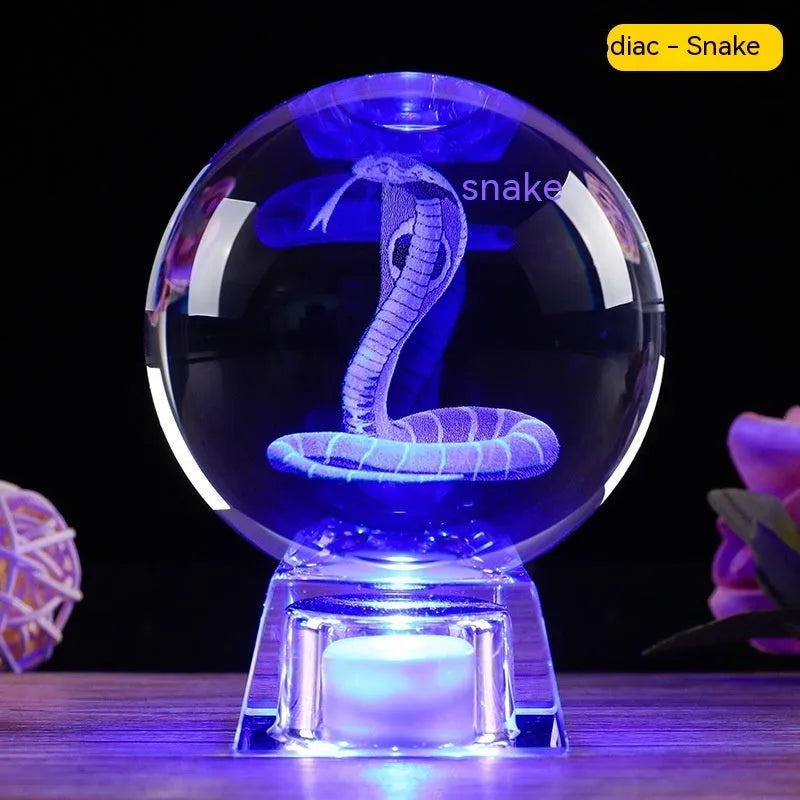 White luminous crystal ball ornament with Chinese zodiac animal figure on electronic base.
