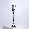 Black cast aluminium sculpture of a woman reading, modern design, 51cm tall.