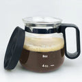 Transparent borosilicate glass coffee maker with black silicone cover on a kitchen counter.