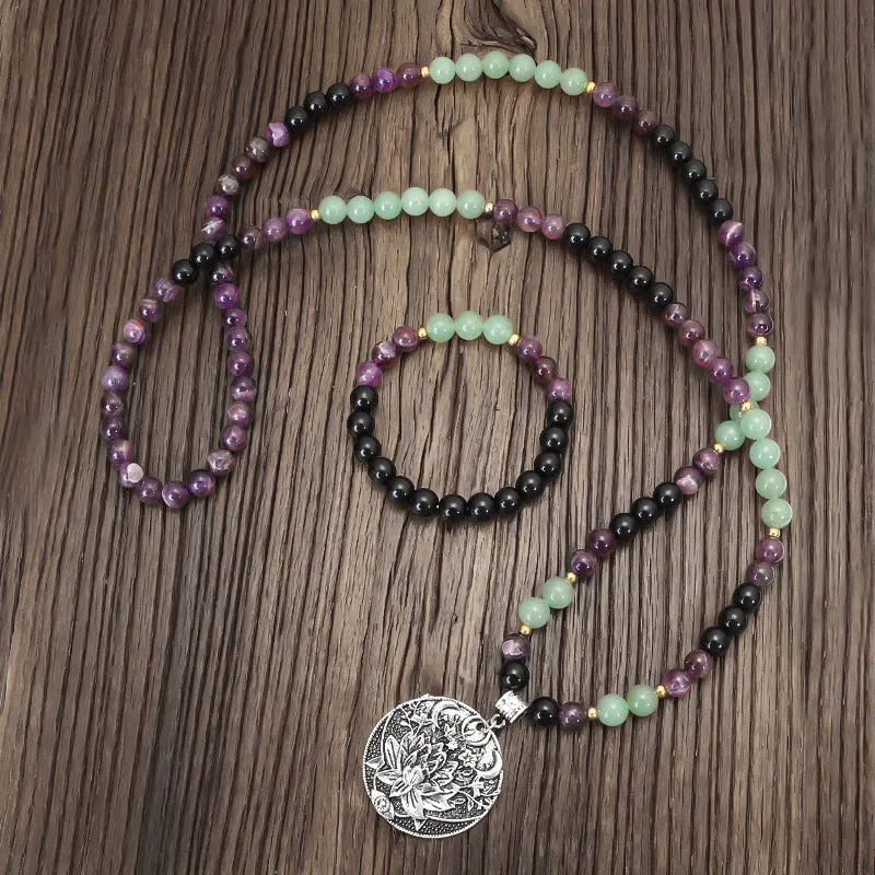 Long yoga necklace with lotus pendant and stone beads alongside matching bracelet