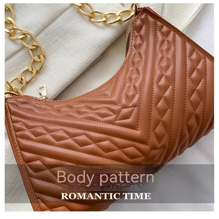 Brown pleated chain baguette women's shoulder bag with adjustable strap on a mannequin.