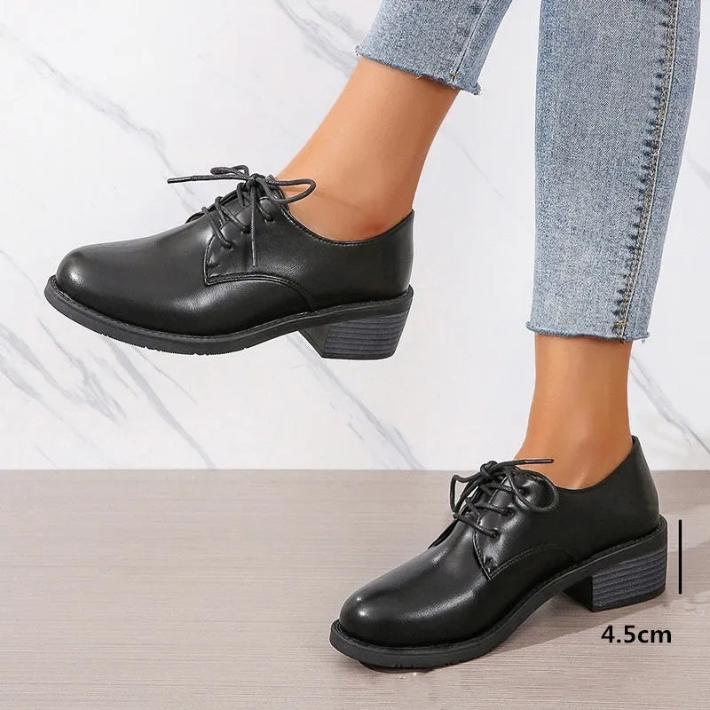 Black women's low-top work shoes with a thick chunky heel and rounded toe.