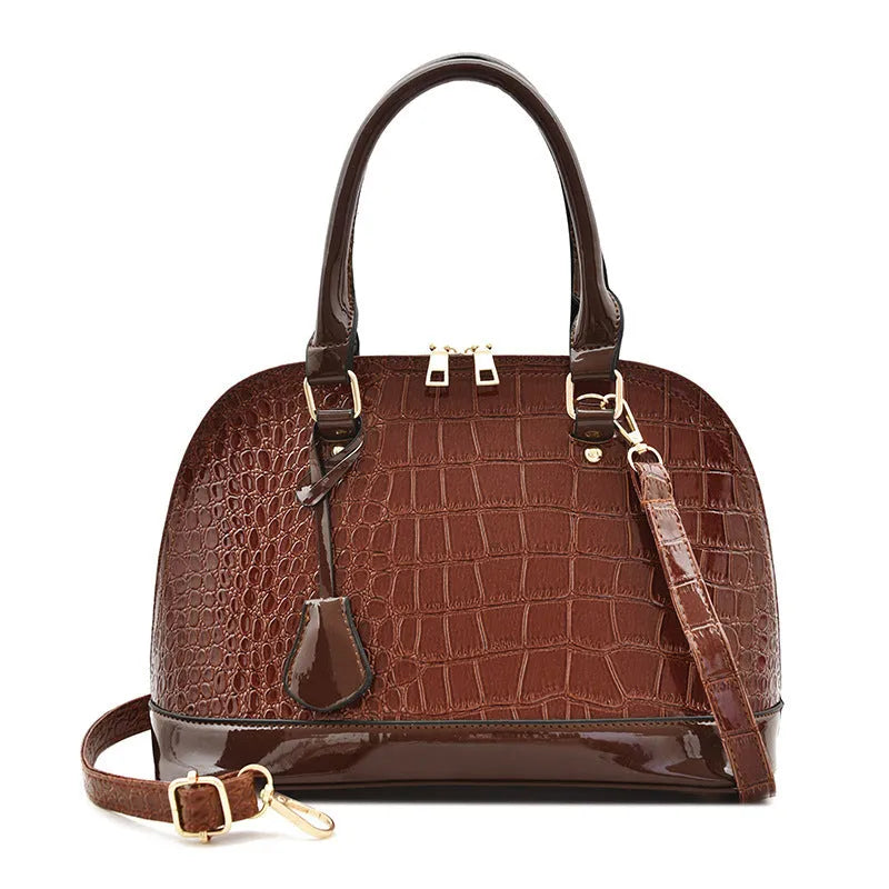 Large shiny black PU leather crossbody shoulder bag showing shell-shaped structure.