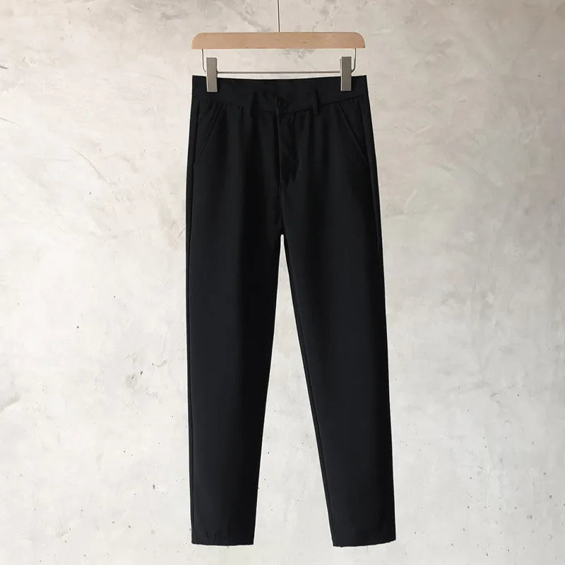 Boy wearing slim straight grey wool trousers with a tapered fit and straight leg opening.