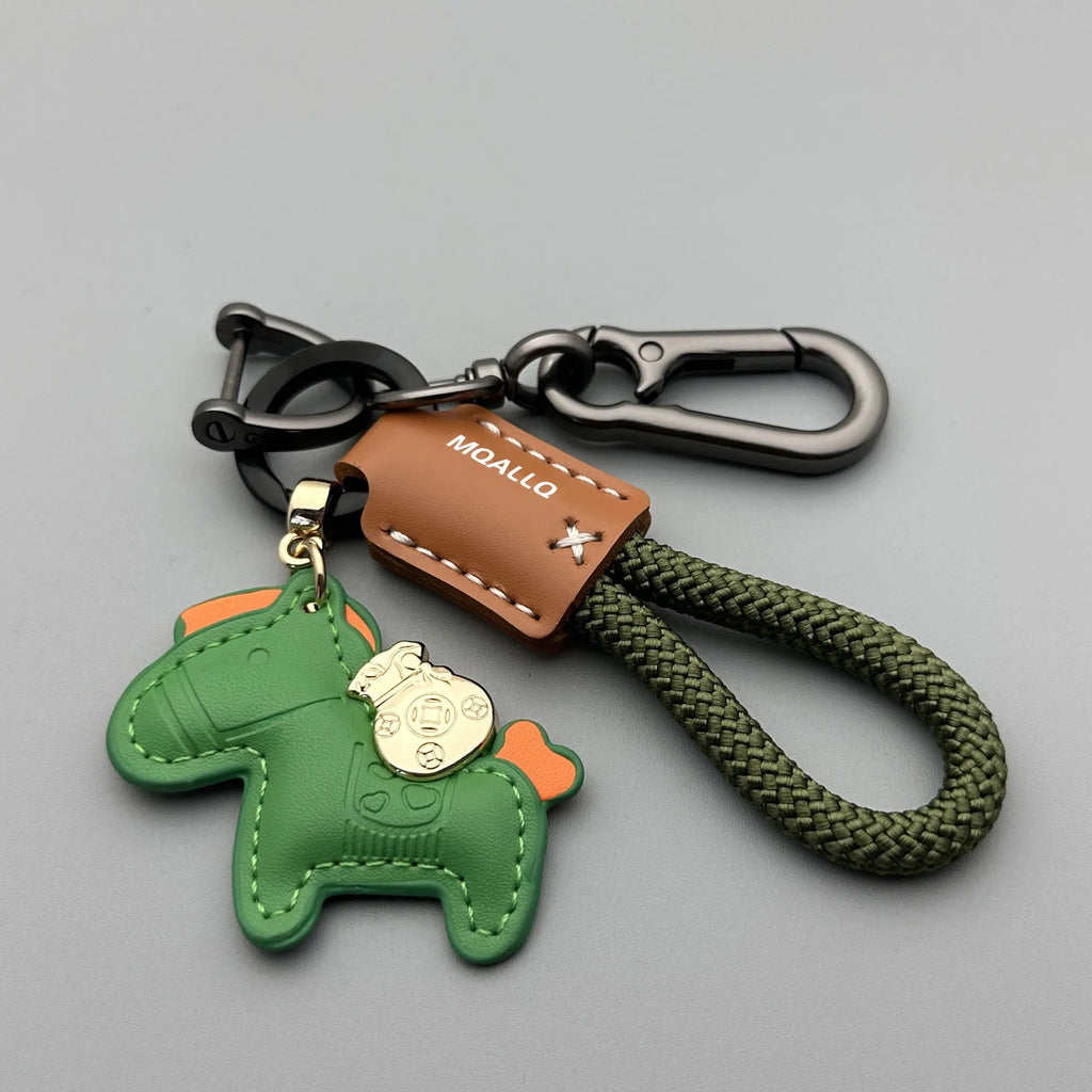 Handmade brown cowhide leather key ring with a gold pony belt buckle charm and a green flanelle rope loop.