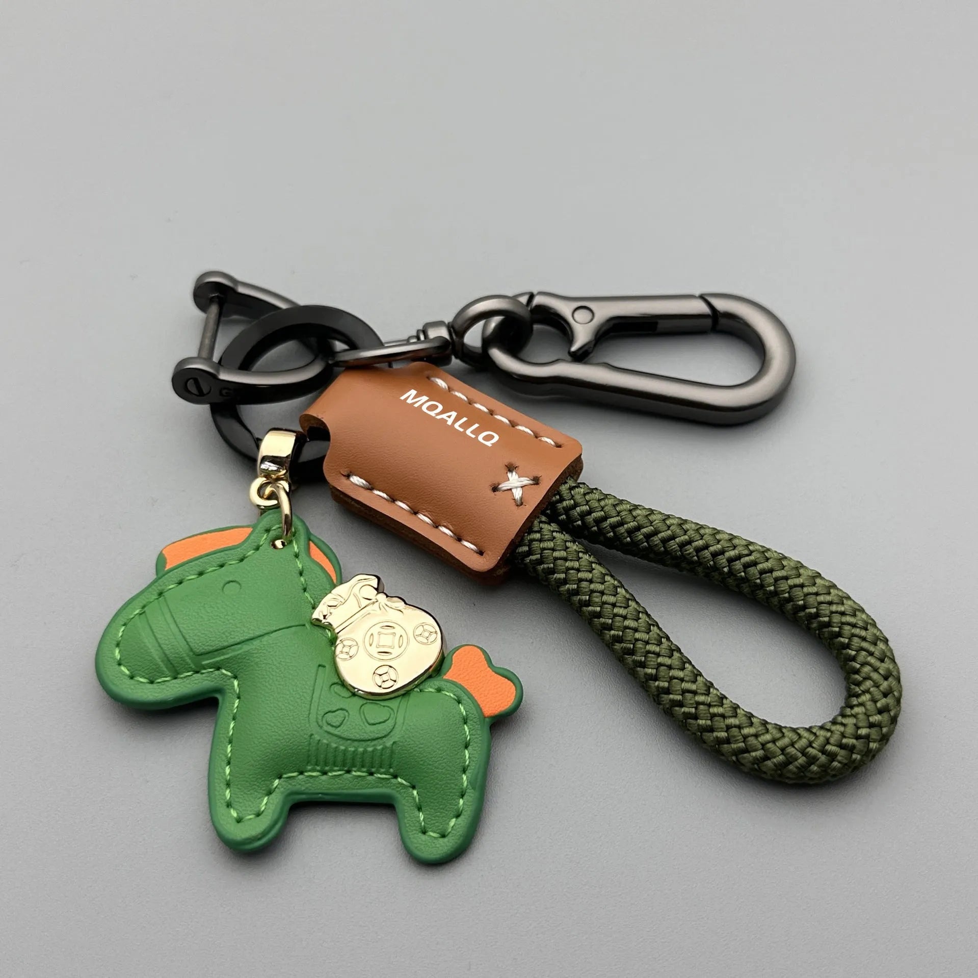 Handmade brown cowhide leather key ring with a gold pony belt buckle charm and a green flanelle rope loop.
