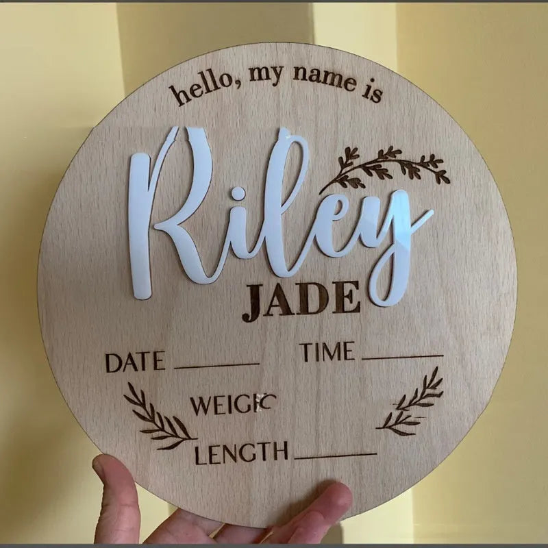 Square wooden baby name label displaying personalised birth details for nursery décor.