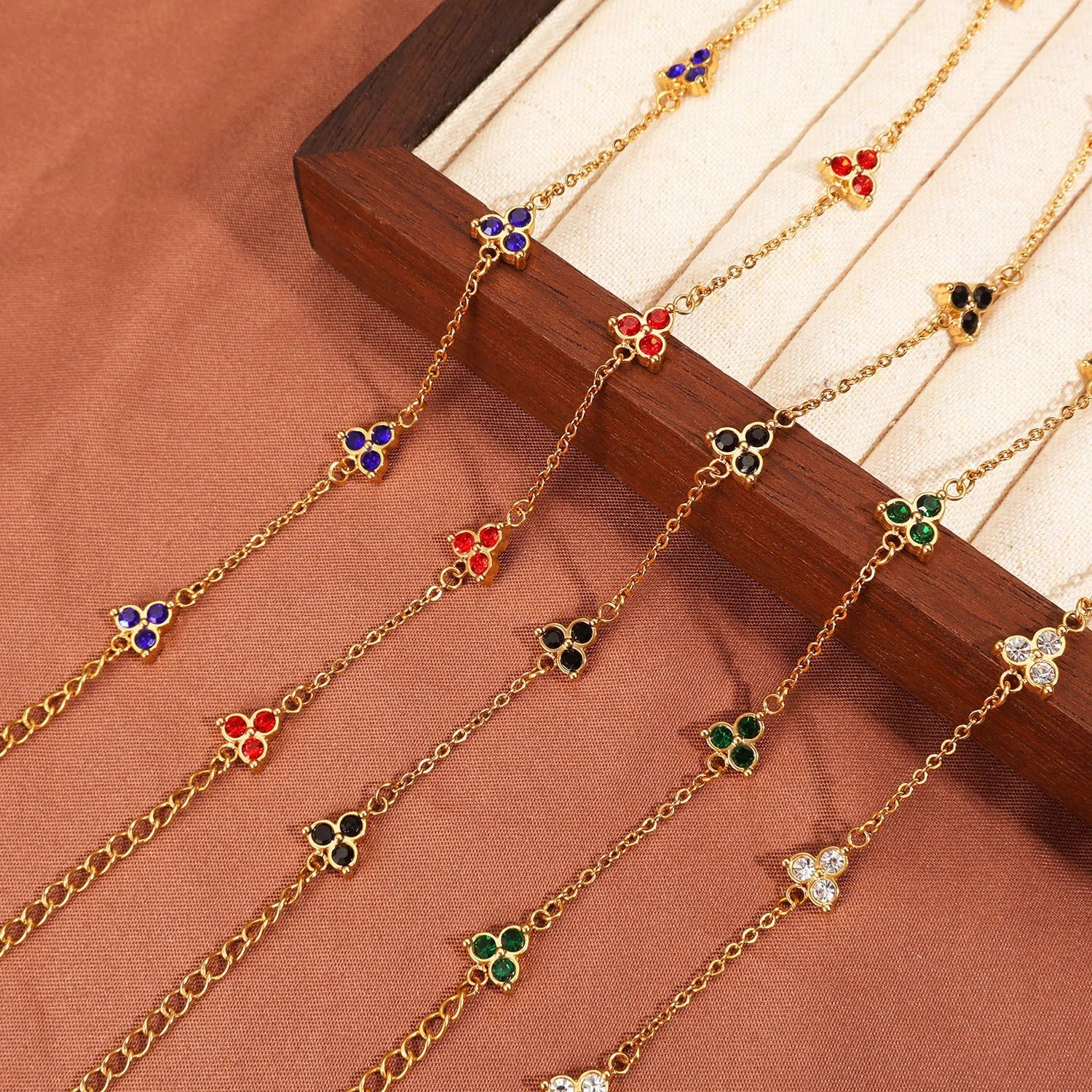 Women's geometric stainless steel bracelet with triple diamond design and coloured stone in gold or steel tone.