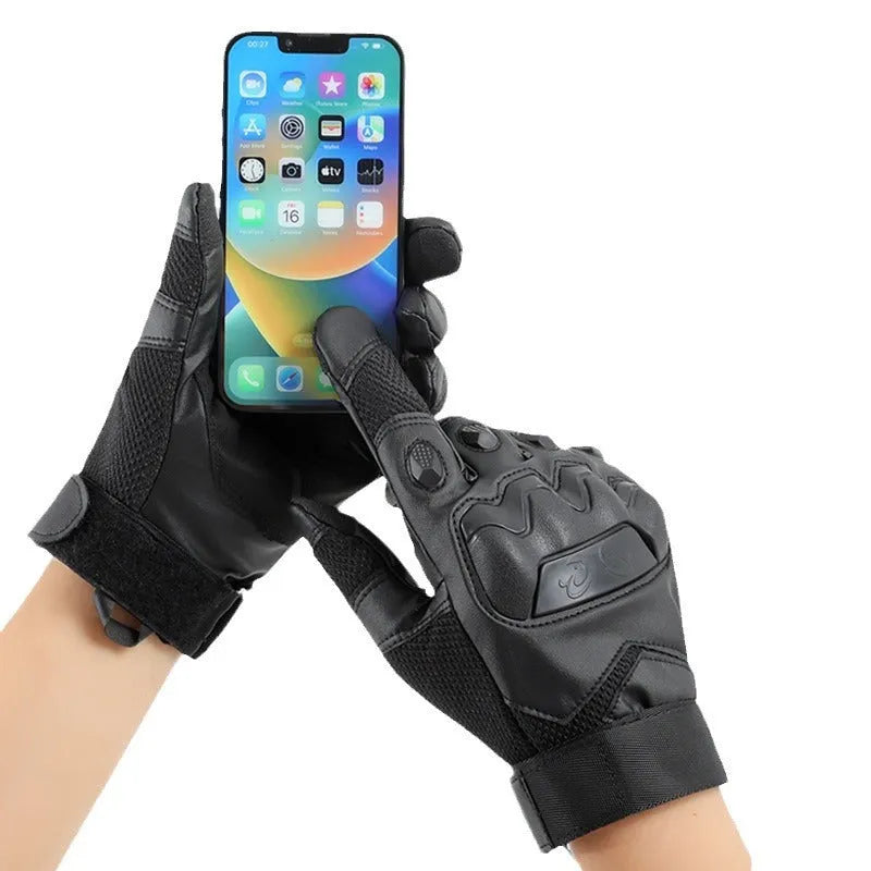 Men's black tactical gloves with touch screen fingertips on a hand holding a smartphone