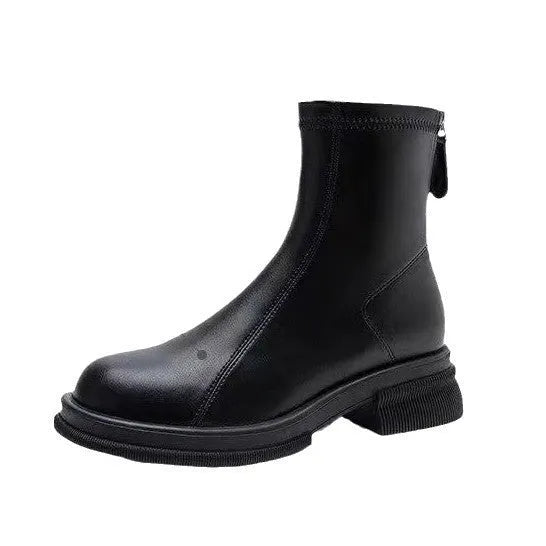 Women's black ankle boots with flat heel, round toe, and back zip fastening on wooden floor