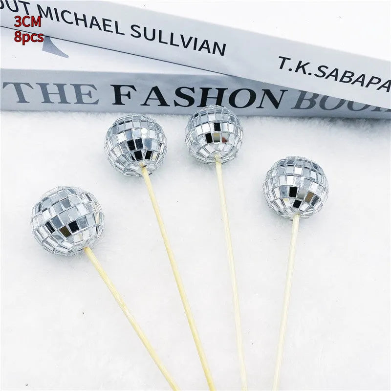Glass mirror disco ball cake topper on a wooden stick for birthday party cupcakes.