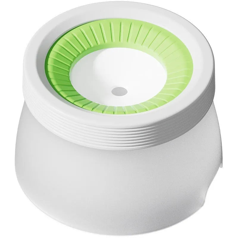 Green non-wet mouth suspension pet water bowl for dogs and cats on a white plate