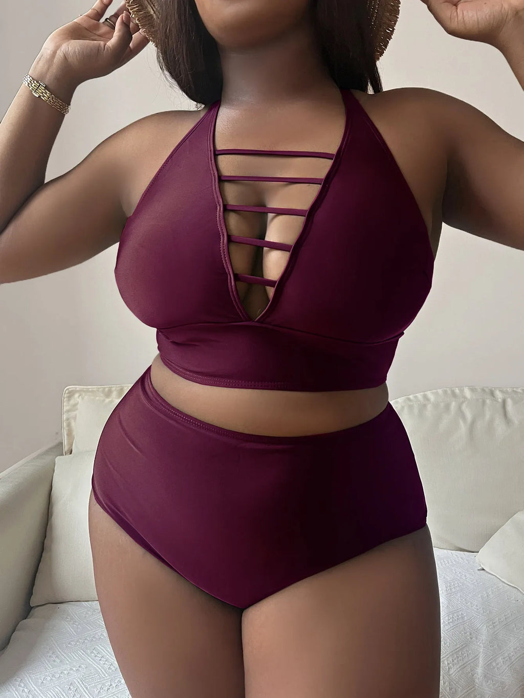 Plus size woman in a black halter bikini with cross-back straps and high-waist briefs on the beach.