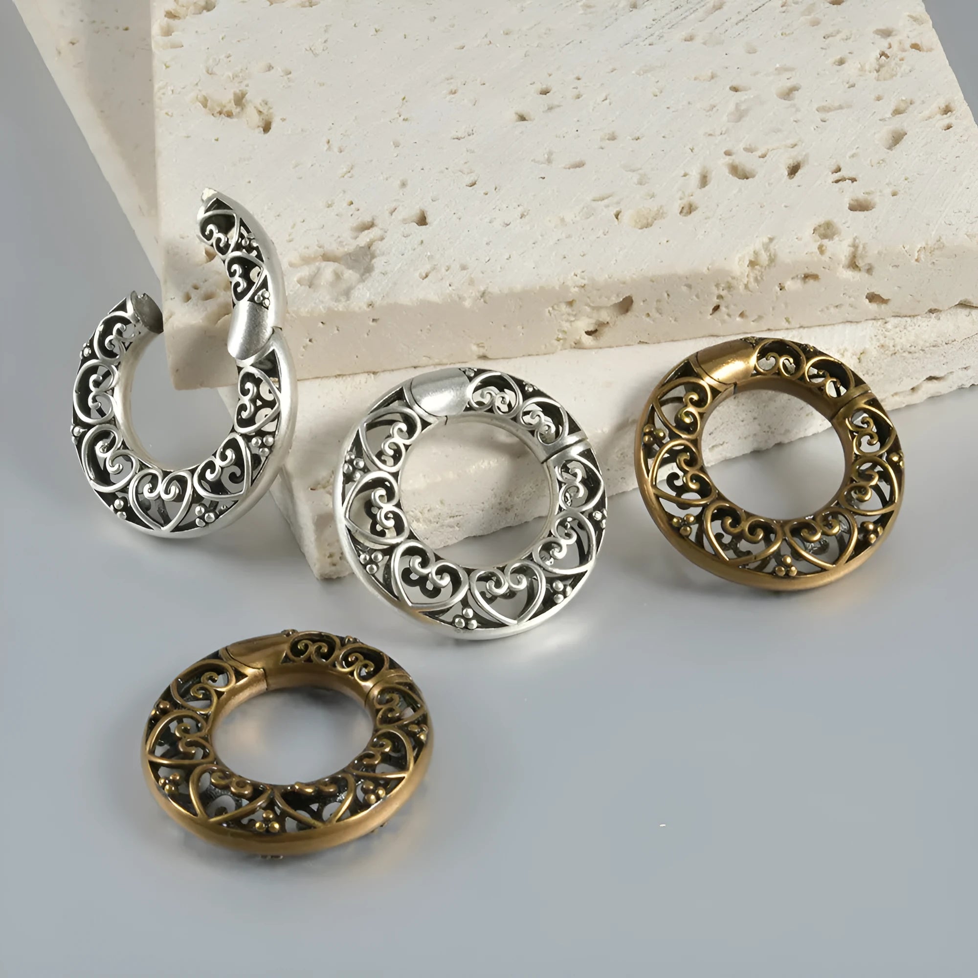 Retro stainless steel magnetic earrings in hollow heart and lotus shapes with antique silver and gold finishes.