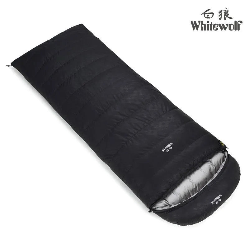 Black outdoor sleeping bag with envelope structure and goose down fill on a campsite.