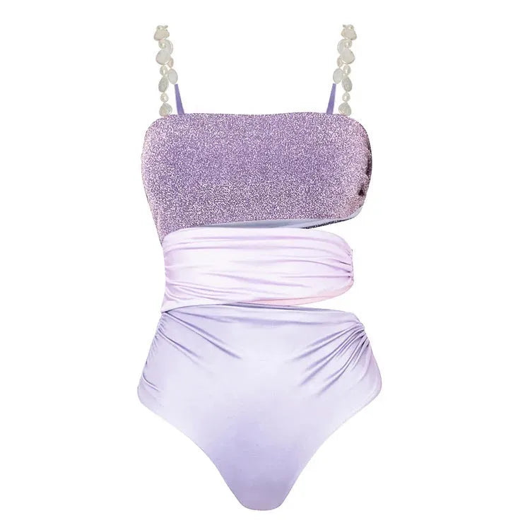 Purple one-piece swimsuit with hollow back and matching wrap skirt laid flat.
