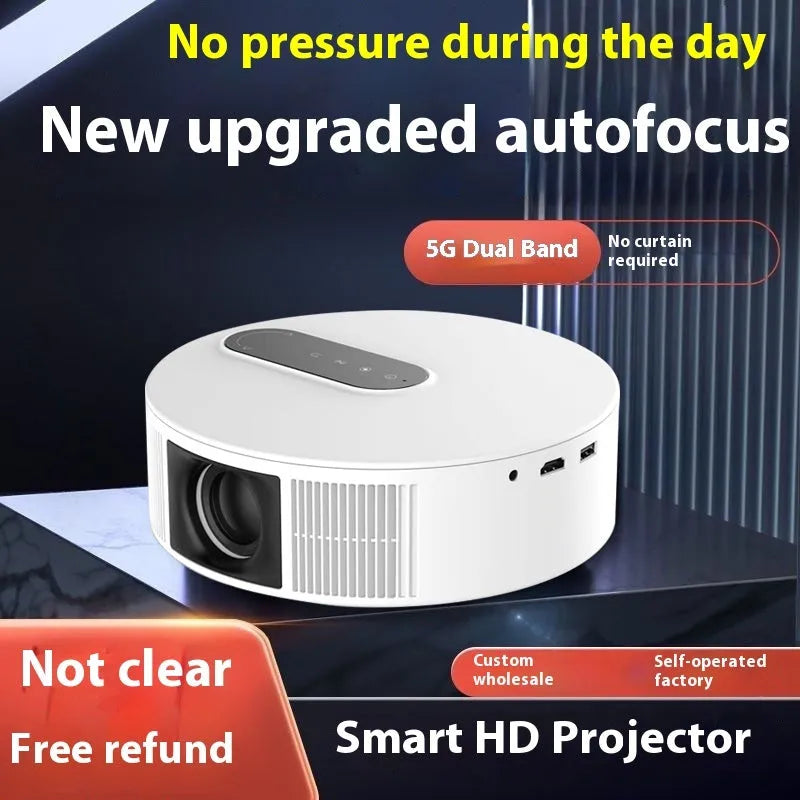 White HD home projector with remote control on a table.