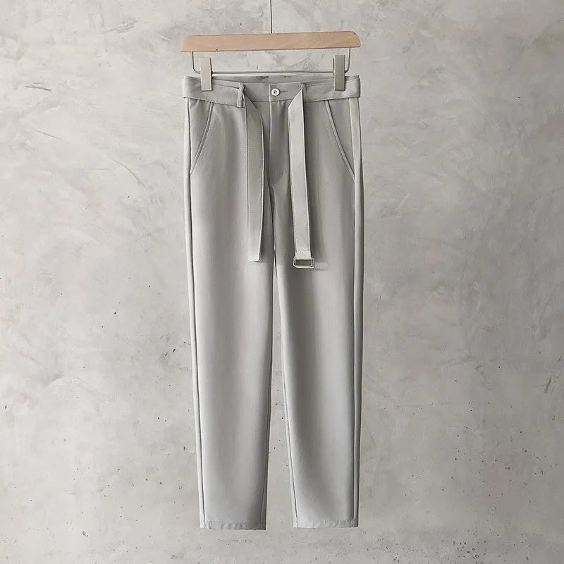 Boy wearing slim straight grey wool trousers with a tapered fit and straight leg opening.