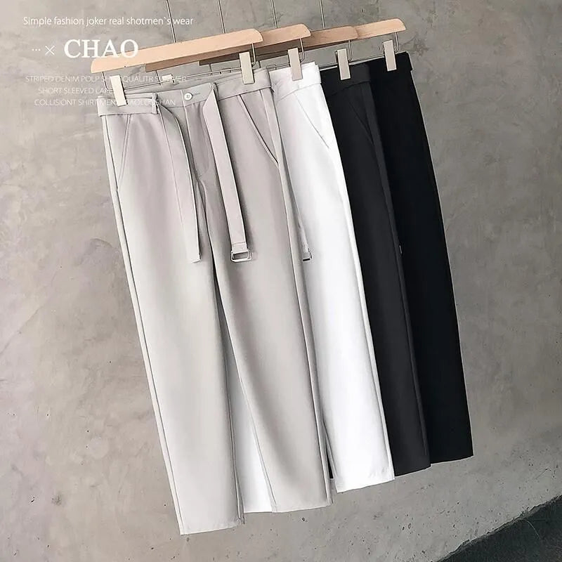 Boy wearing slim straight grey wool trousers with a tapered fit and straight leg opening.