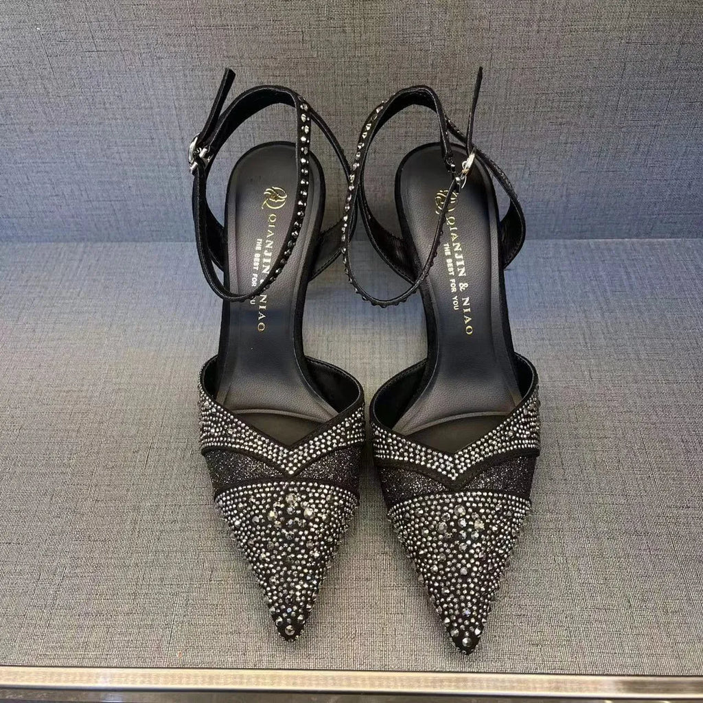 Women's black hollow cut stiletto high heels with pointed toe and red sole on a white background