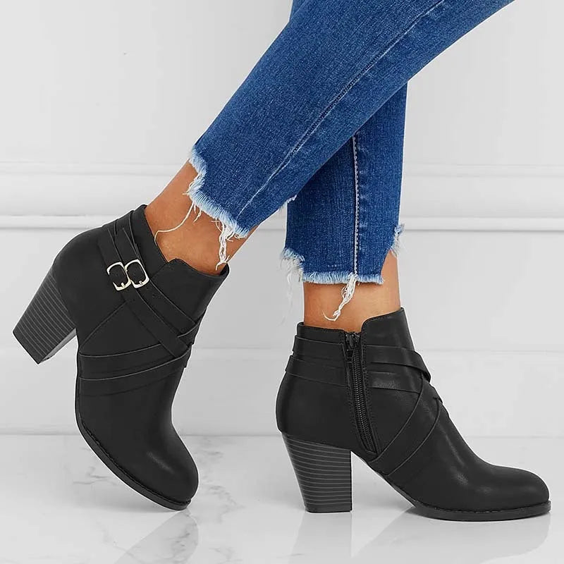 Grey plus-size short boot with 7cm heel, side zip, and buckle detail on a wooden floor