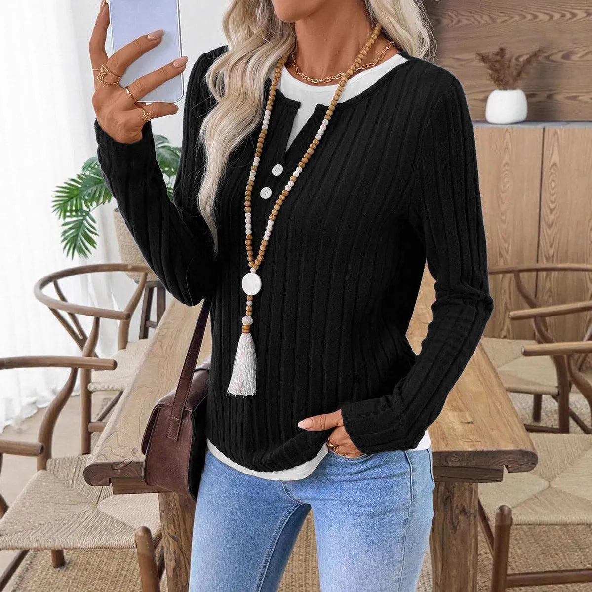 Women's black grinding stripe fake two-piece pullover sweater with round neck and button detail.