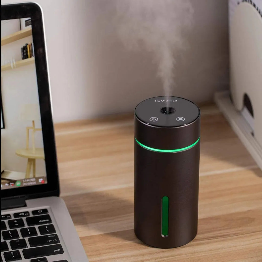 Black aluminium portable car air humidifier and essential oil diffuser unit with USB cable.
