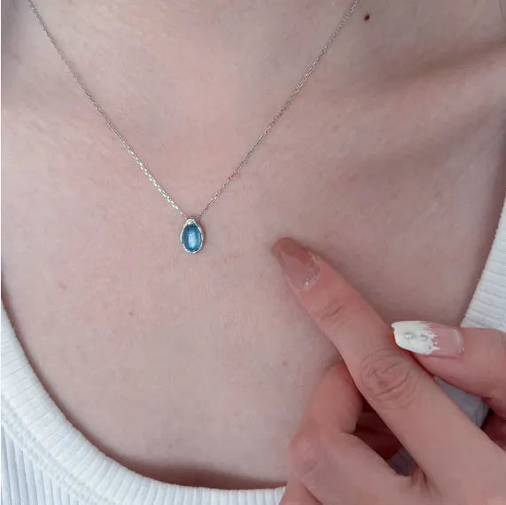 Navy blue geometric water drop pendant necklace with cross chain design on white background