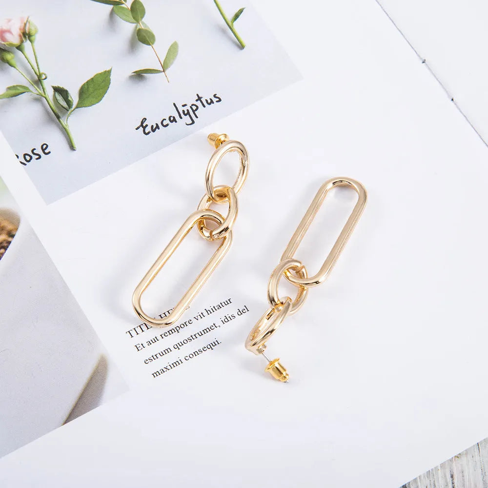 Sterling silver geometric hoop earrings with ring and line design on silver background