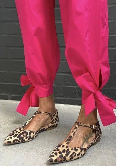 Leopard print women's pumps with a pointed toe, cross straps, and a chunky low heel.