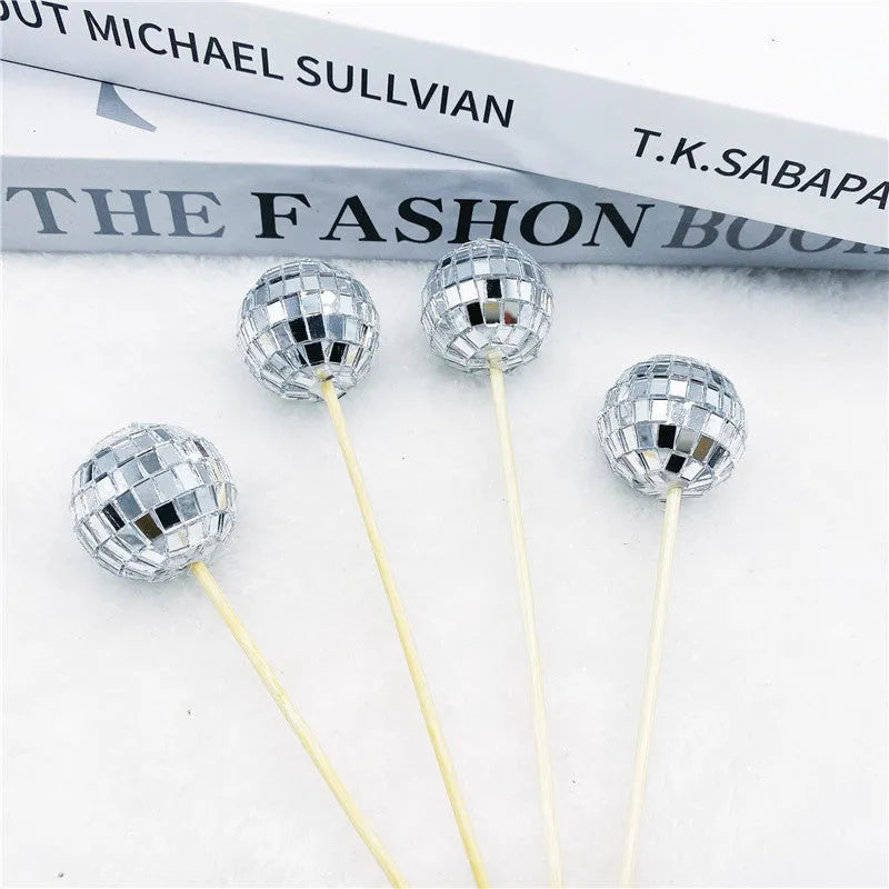 Glass mirror disco ball cake topper on a wooden stick for birthday party cupcakes.