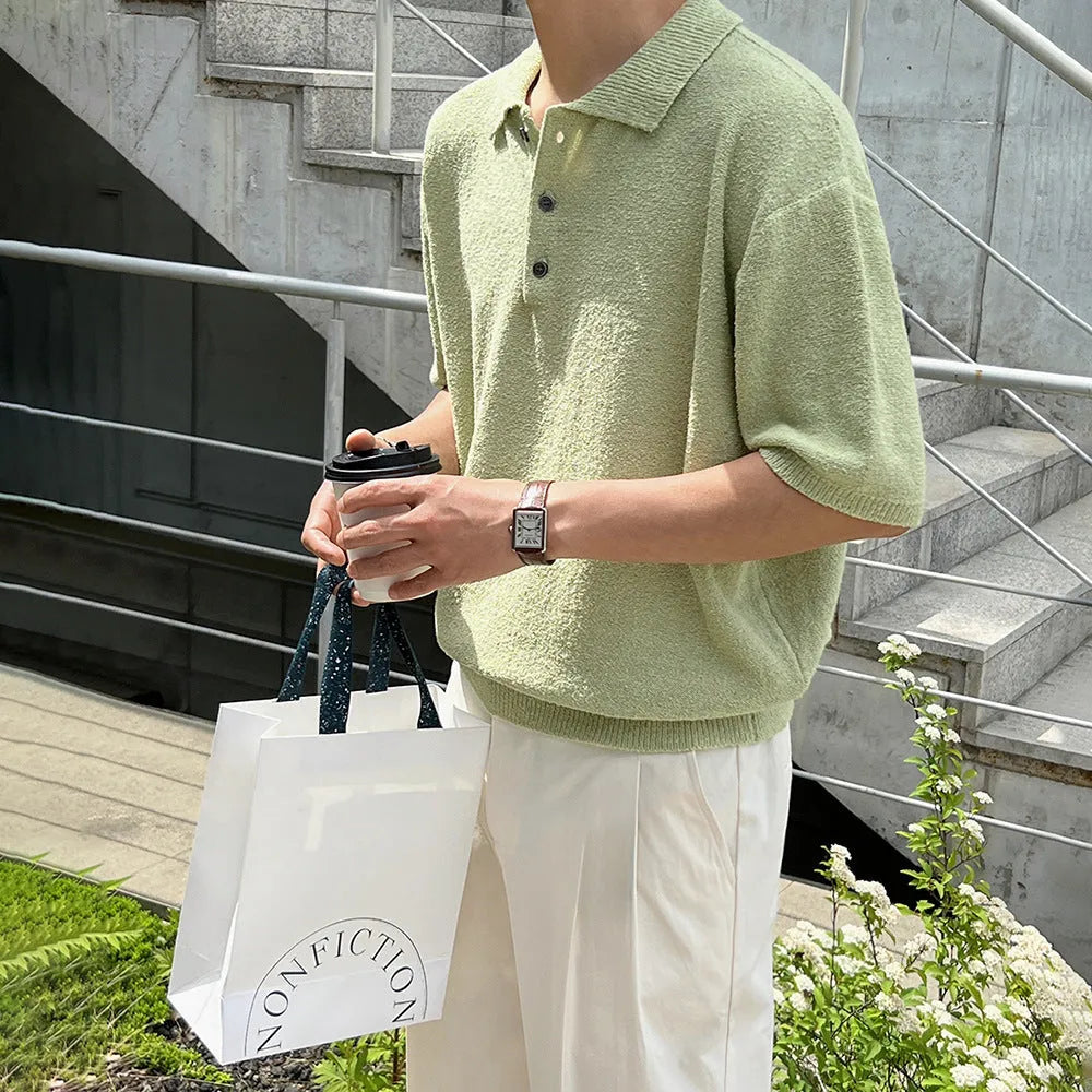Man wearing a caramel-coloured loose-fit knitted polo shirt with short sleeves and an asymmetrical design detail.