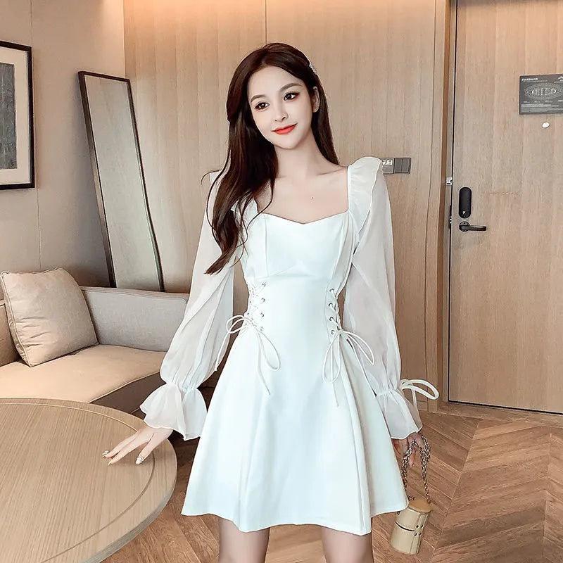 White chiffon patchwork dress with long sleeves and a slim, waist-defining fit on a mannequin.