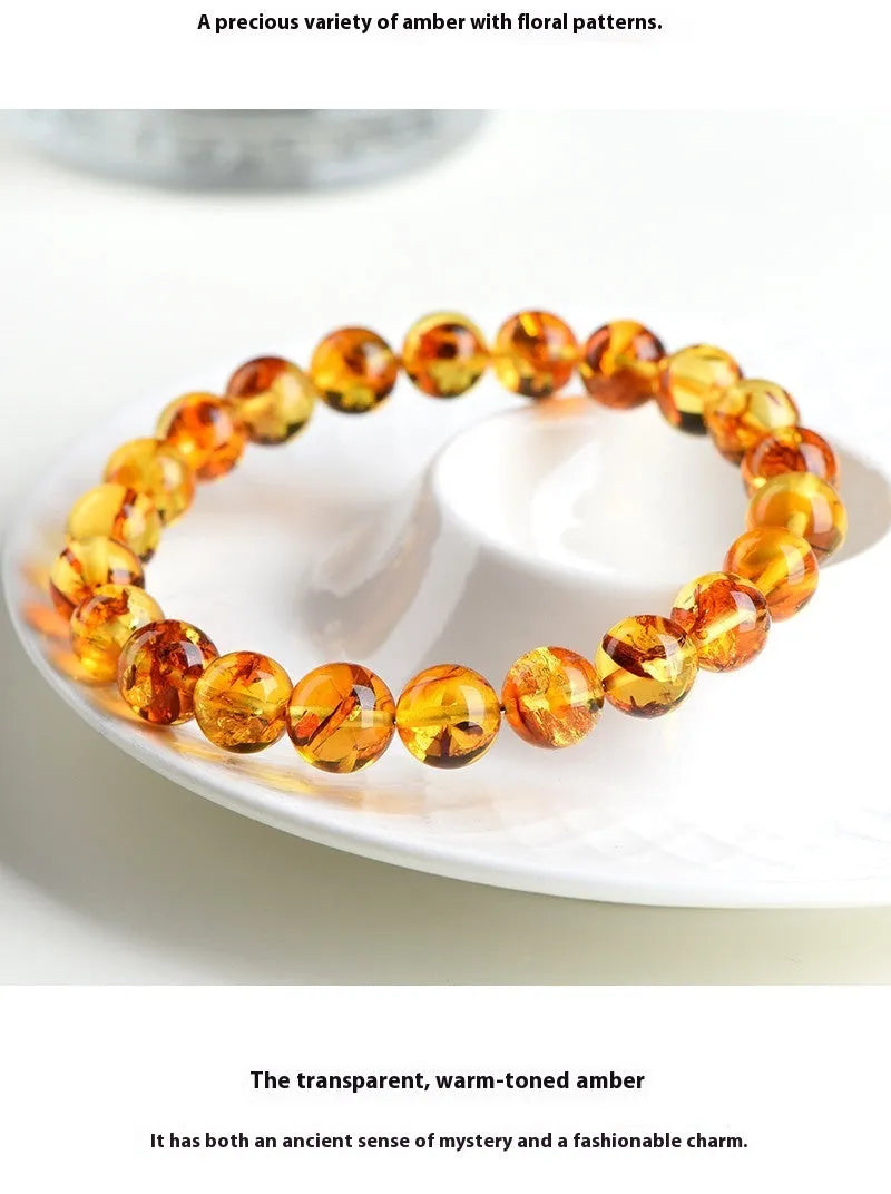 Natural yellow piebald amber bracelet with geometric beads on a white background.