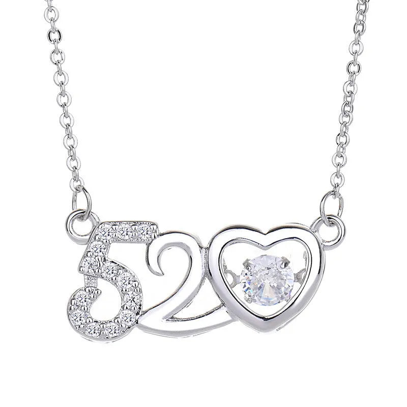Silver tone heart pendant necklace with crown and bow charms on model