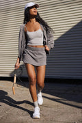 Women's blue hooded zip-up jacket and matching miniskirt streetwear outfit set on a hanger