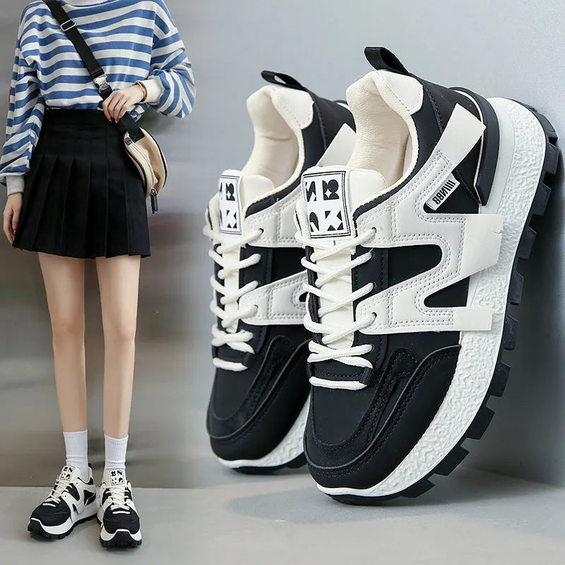 Unisex low-top sneaker in black with round toe, flat heel, and lace-up front on a rubber sole.