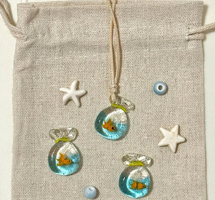 Women's necklace with coloured glaze joker pendant on a woven cotton and linen clavicle chain.
