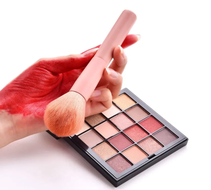 Ten professional makeup brushes with wooden handles arranged in a set, including powder, foundation and detail brushes