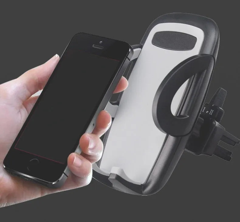 Black car air vent mobile phone holder attached to air conditioning outlet holding smartphone