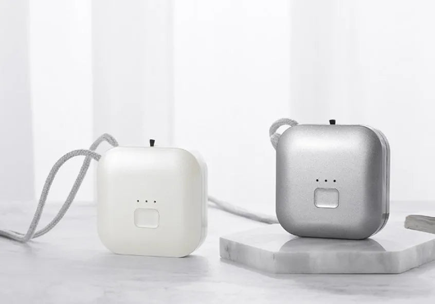 Mini USB portable air purifier necklace in blue, shown next to its charging cable.