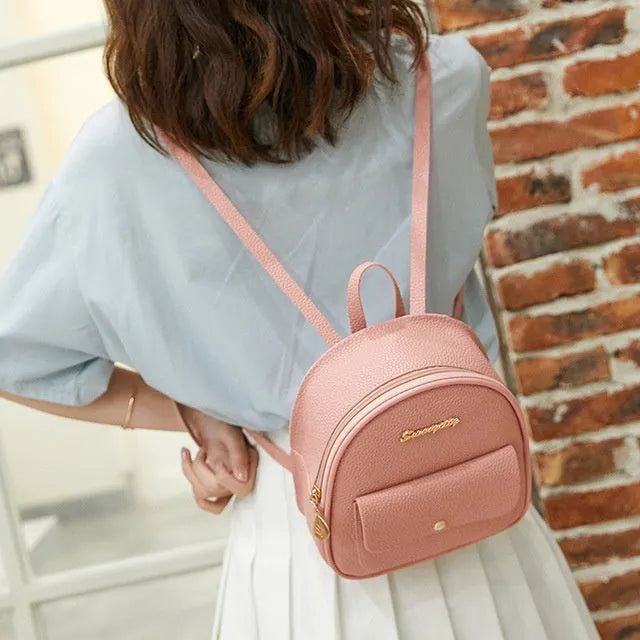 Women's small PU backpack shoulder bag in black, blue, grey, pink, or red with zipper closure