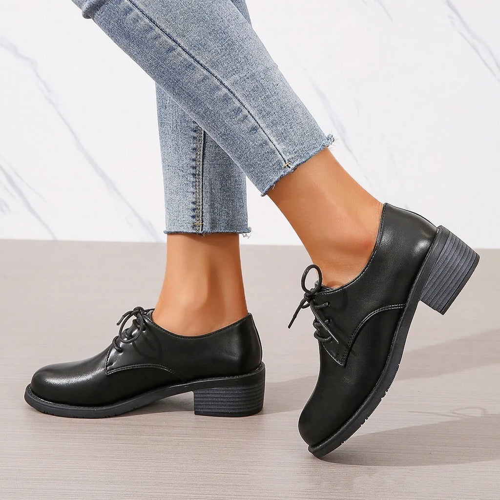 Black women's low-top work shoes with a thick chunky heel and rounded toe.