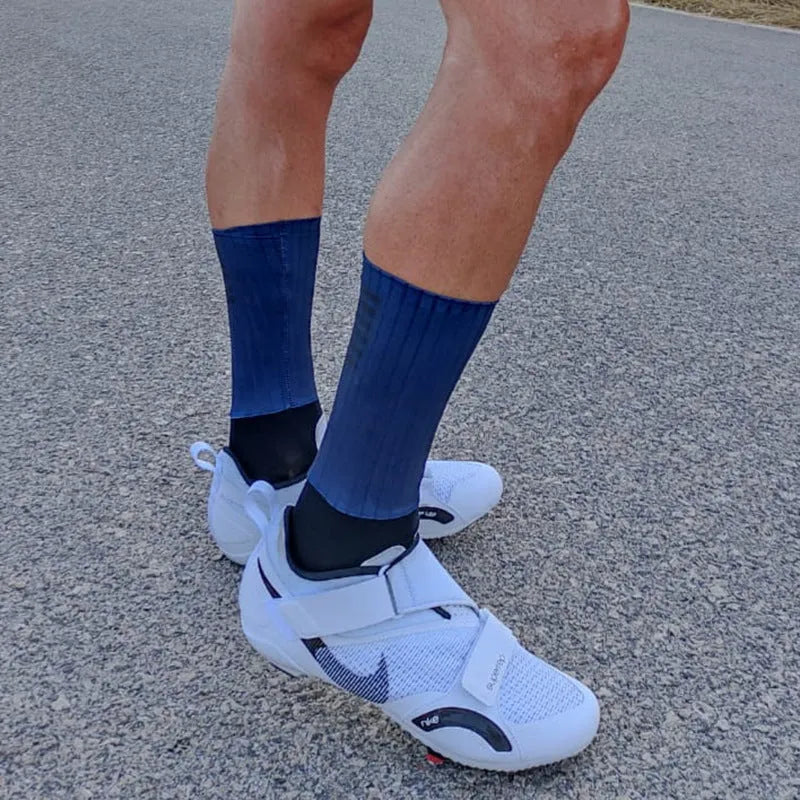 A pair of athletic cycling and running socks in a moisture-wicking fabric blend on a grey background.