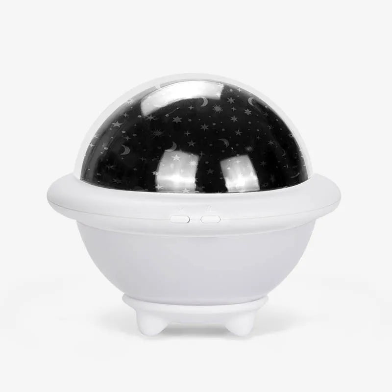 Pink UFO-shaped plastic LED night light projecting a starry sky pattern on a wall.