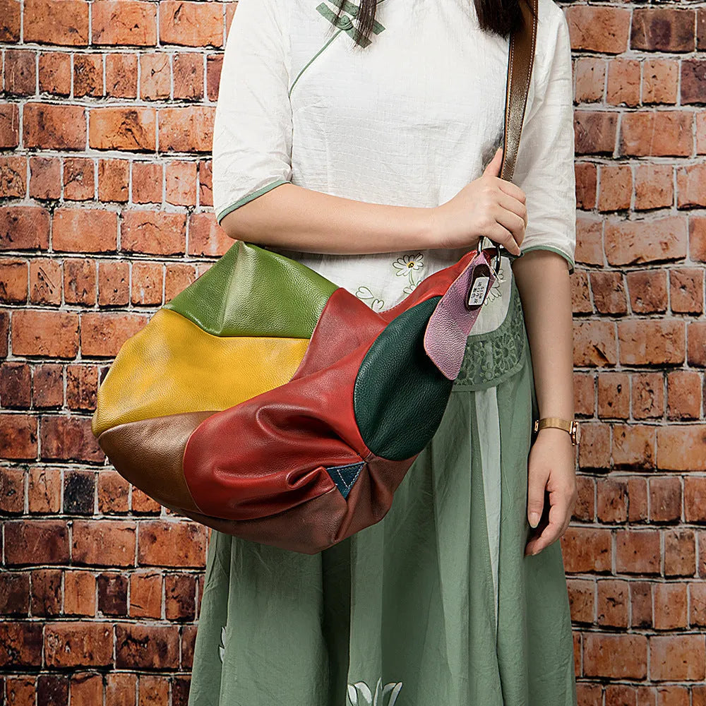 Brown cowhide leather travel bag with contrast stitching, shown as a crossbody bag.
