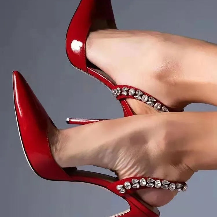 Black patent leather women's high heel sandals with pointed toes and side rhinestone straps.